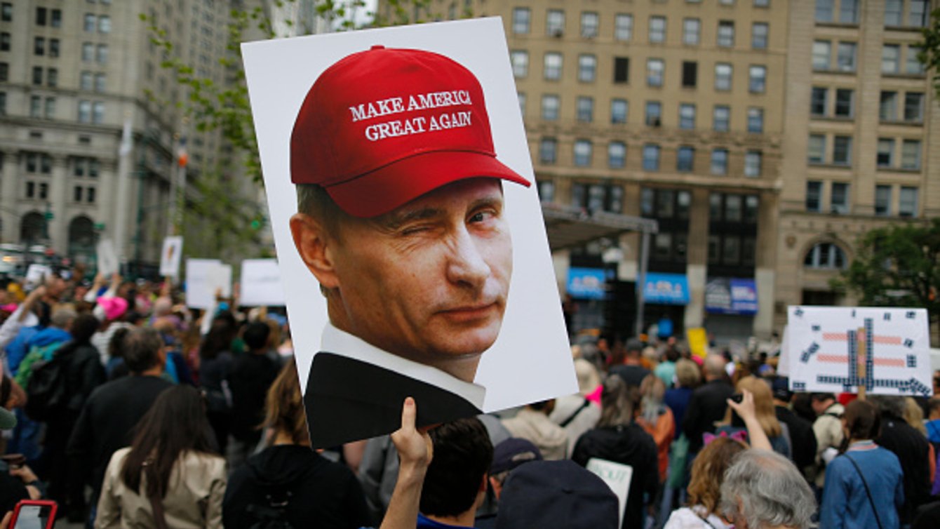 Protest sign of Putin wearing MAGA hat