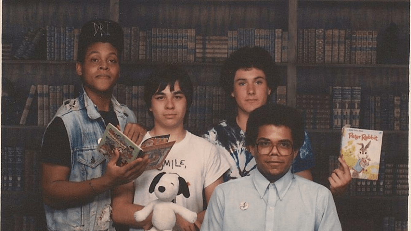 Young Eric Ward posing with friends holding books