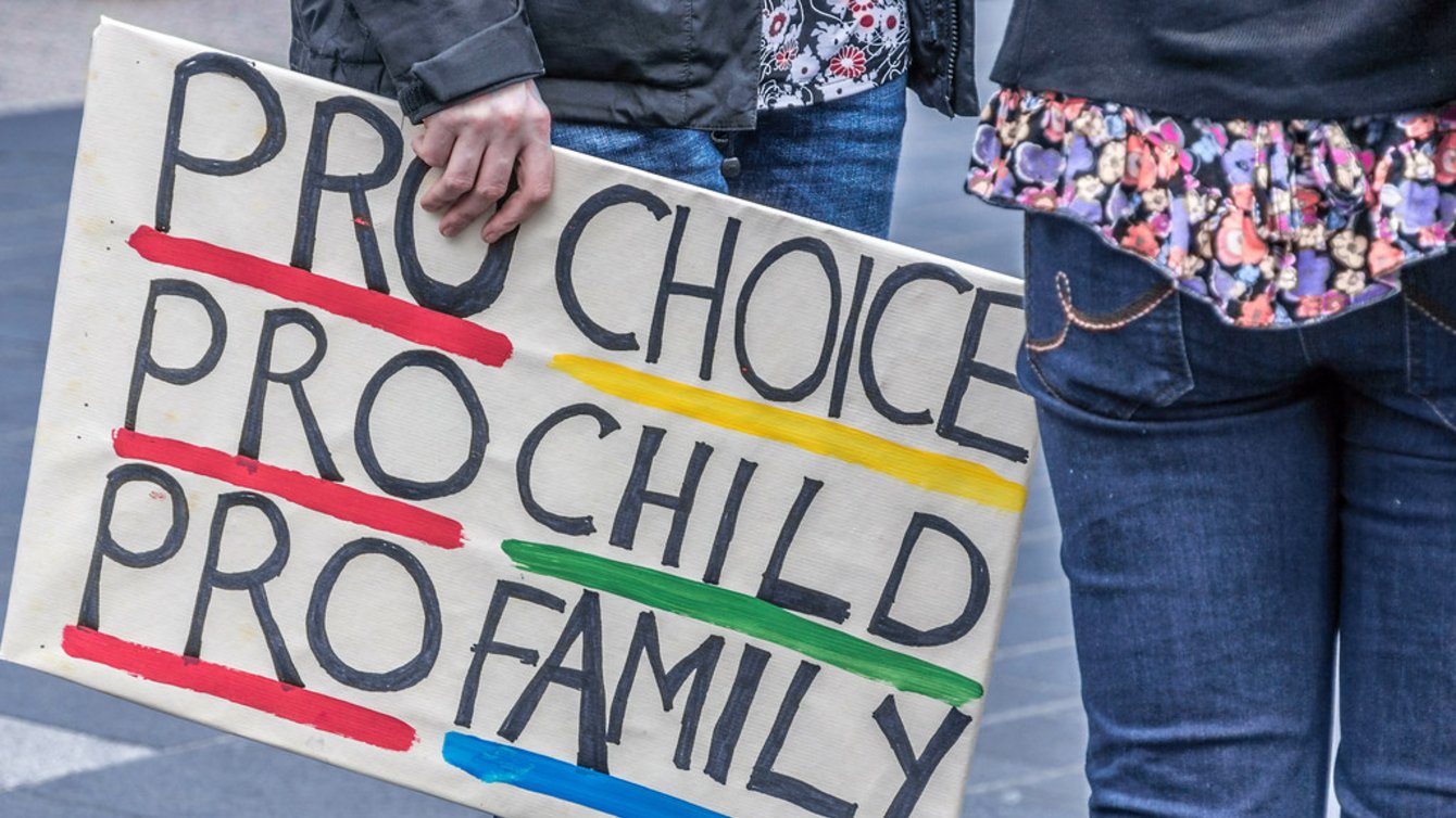 A banner at a protest that says "Pro Choice, Pro Child, Pro Family"