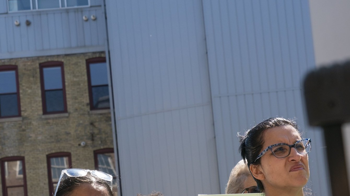 Woman holding sign that reads "I pledge to always teach the truth"
