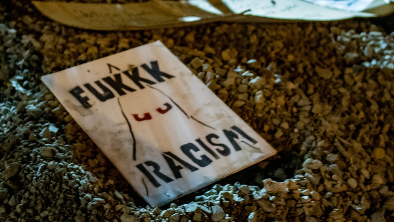 A sign that says Fukkk Racism