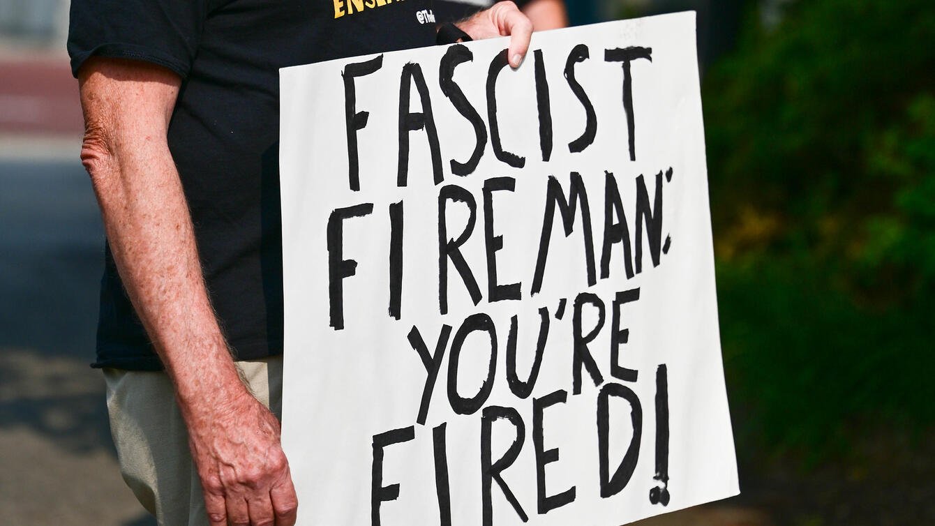 a sign that says "Fascist Fireman: You're Fired!"