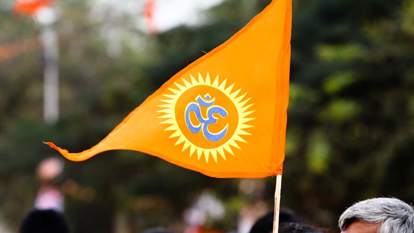 An orange triangle flag with an "Om" on it.