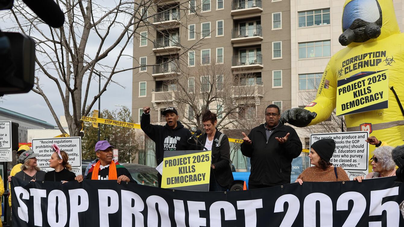 A protest banner reads, "Stop project 2025"