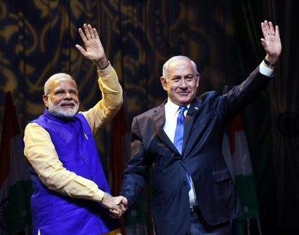 Narendra Modi and Benjamin Netanyahu shaking hands and waving into the crowd.