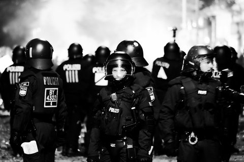A group of men in german police gear wearing helmets. One man is looking straight at the camera.