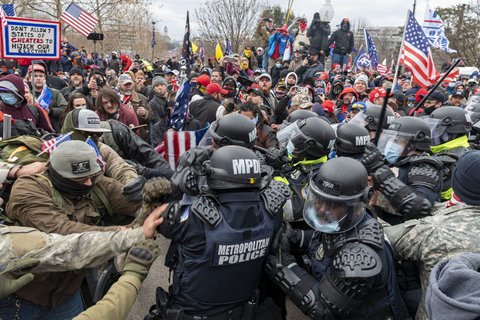 insurrectionists clashing with police on January 6th. Men are pushing against each other.