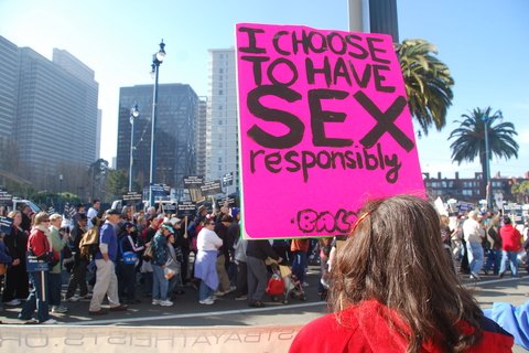 A person holding a sign that reads "I choose to have sex responsibly"