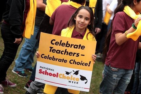A young girl holding a sign that says Celebrate Teachers - Celebrate Choice! National School Choice Week
