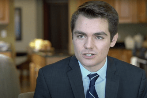 A young white man, Nick Fuentes, in a suit