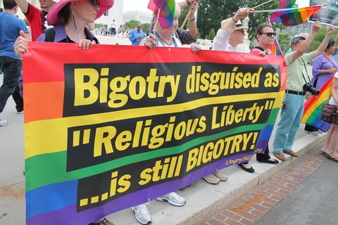 A rainbow flag with the words: Bigotry disguised as "Religious Liberty" is still Bigotry!