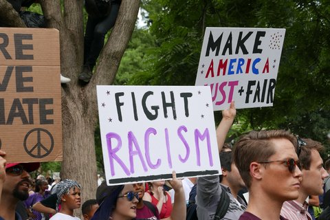 A person holding a sign saying "Fight Racism"