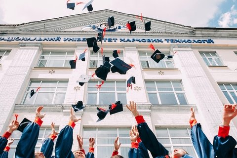 Graduation hats being thrown in the air