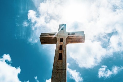 A wooden cross against a blue sky.
