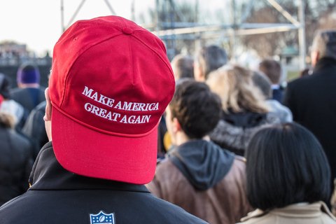 A Person wearing a MAGA hat backwards.