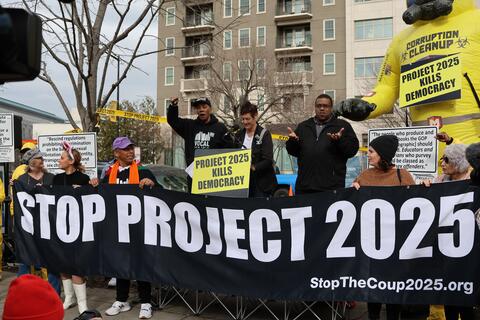 A protest banner reads, "Stop project 2025"