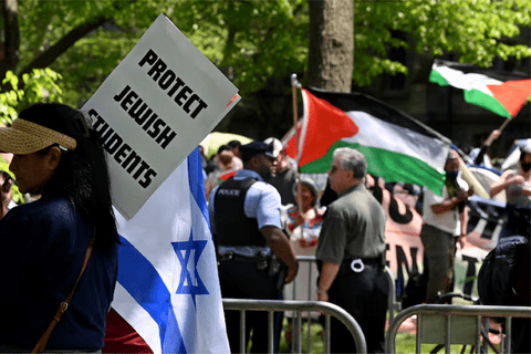 a protest with Palestinian flags and a sign that says "protect jewish students"