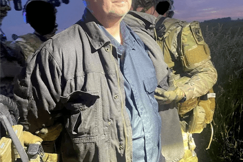 a man in a grey jacket being handcuffed