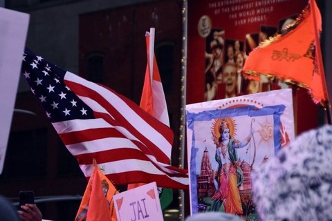 American and saffron flags around a framed picture of the deity Ram.