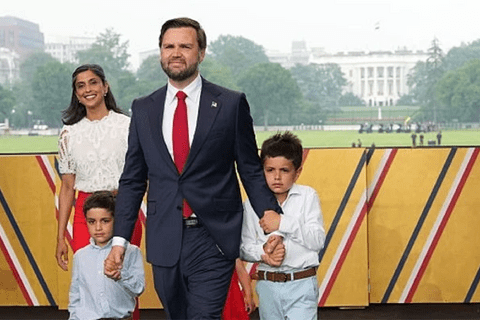 a picture of JD Vance with his wife Usha Vance and their two children between two US flags