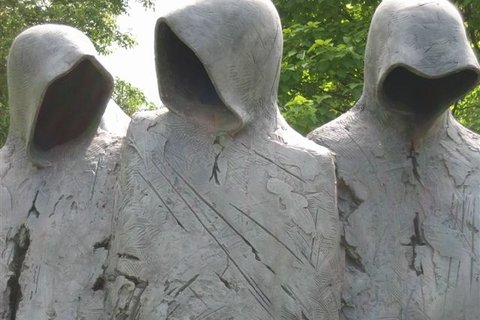 statues of people wearing hoods
