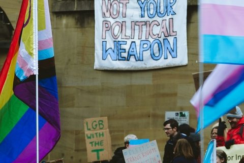 Protest image with flag that reads "Not Your Political Weapon"