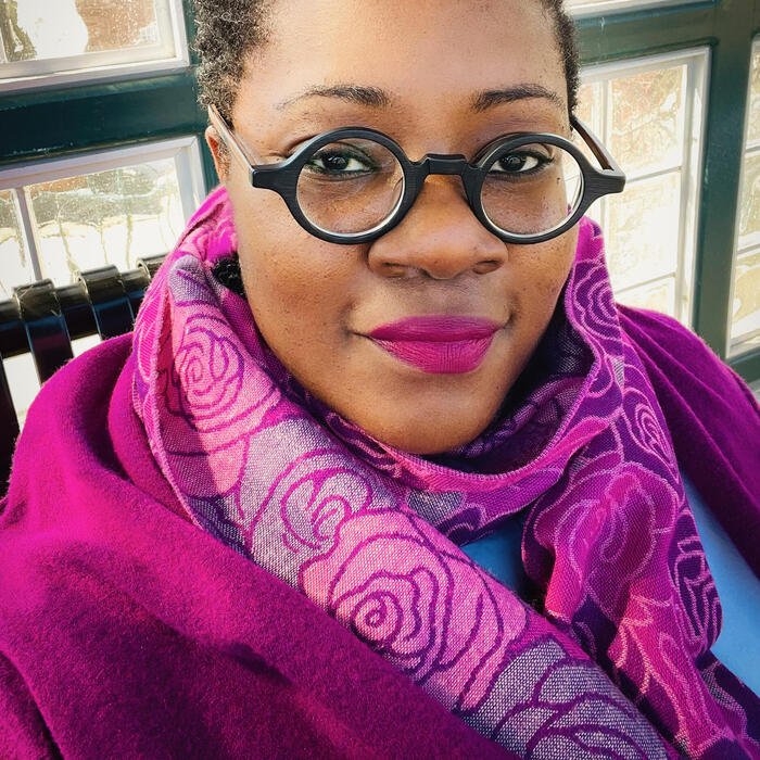 a woman in a pink scarf wearing glasses